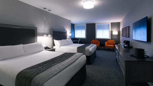 魁北克市维多利亚庄园酒店的酒店客房配有两张床和一张书桌