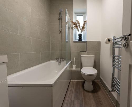 雷丁Elms House, sleeps 5, free parking的带浴缸、卫生间和盥洗盆的浴室