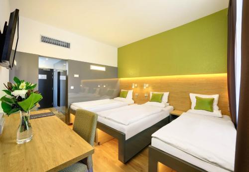 布拉格布拉格阿米西斯特酒店的酒店客房设有两张床和一张桌子。