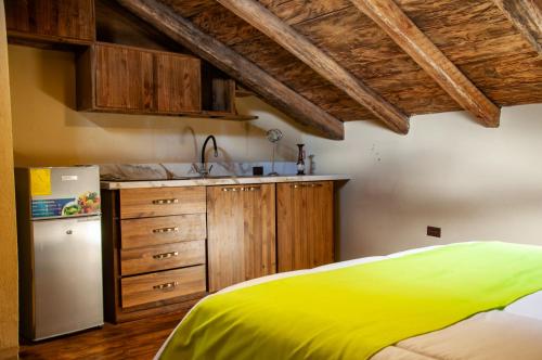 昆卡Casa Suite Campana的厨房配有黄色的床和冰箱