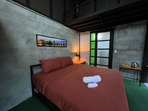 春蓬เป่าฟู่เฮ้าส์ Bao Fu's House的一间卧室配有红色的床和2条毛巾
