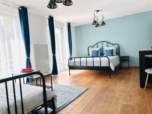 兰斯Reims Sherpa Guest House的一间卧室配有一张蓝色墙壁和木地板。