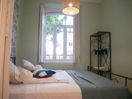 塞图巴尔Setubal History - By Y Concept的一间卧室设有一张大床和窗户