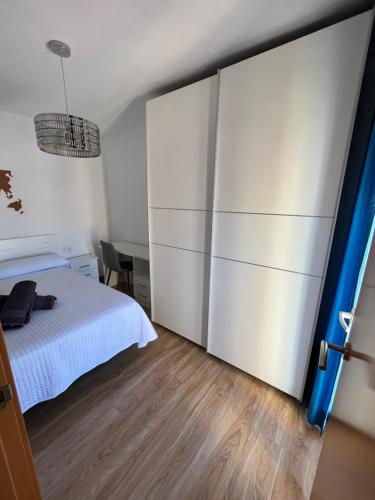 格拉纳达Bonito apartamento en Granada (zona palacio congresos y metro)的卧室配有白色的床和推拉门。