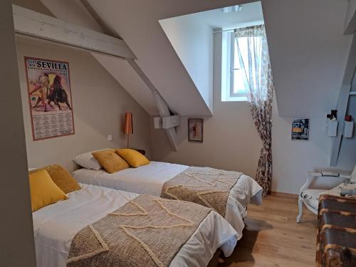 au milieu coule la Garonne的一间卧室设有两张床和窗户。