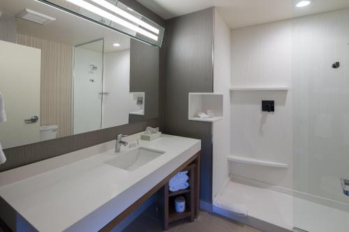 贝城卡提亚德湾城酒店的一间带水槽、淋浴和镜子的浴室