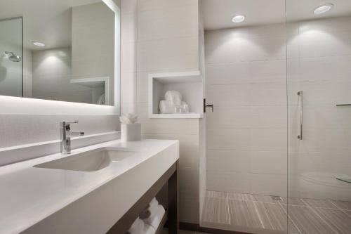 奥兰多Courtyard by Marriott Orlando South/Grande Lakes Area的白色的浴室设有水槽和淋浴。