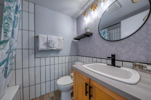 潘诺拉马Panorama Resort 2 Bedroom Creekside Condo的一间带水槽、镜子和卫生间的浴室