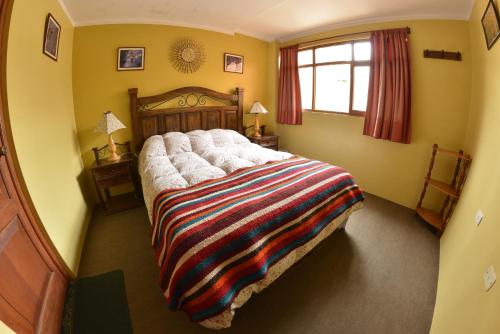 瓦拉斯La Casa de Zarela的一间卧室配有一张大床,床上有色彩缤纷的毯子