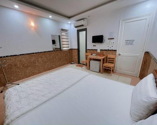 头顿Hoài Thu Hotel Vũng Tàu的卧室配有一张白色的大床和一张桌子