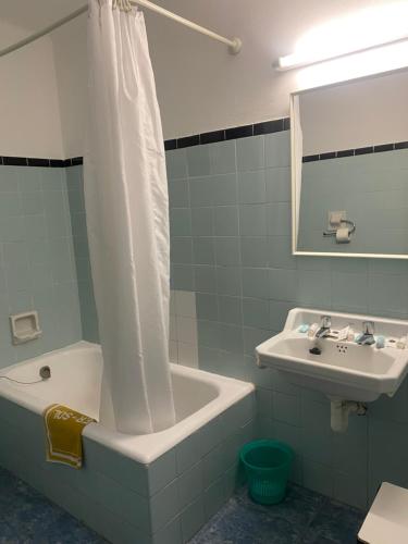 罗列特海岸Clipper Affiliated by FERGUS的带浴缸、水槽和淋浴帘的浴室