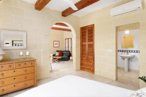 加斯利Dar ta' Lonza Villa with Private Pool的大型客房设有水槽和一间卧室。
