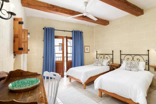 加斯利Dar ta' Lonza Villa with Private Pool的一间卧室配有两张床和一张桌子
