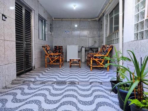 瓜鲁柳斯Pousada Guarulhos的阳台配有2把椅子和1张桌子,位于地面楼层