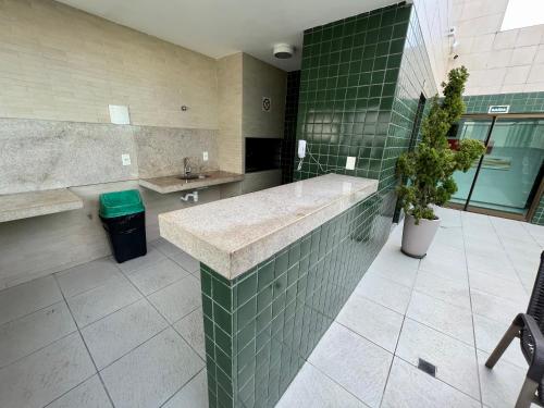 马塞约Apartamento Maceió - De frente a Praia de Jatiuca的浴室铺有绿色瓷砖,设有大型水槽。
