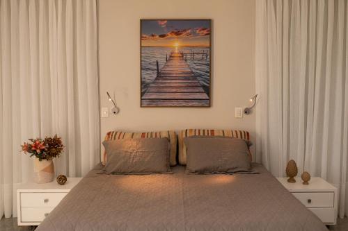 维多利亚Casa 4 Suítes - Ilha do Boi的卧室配有一张床,墙上挂有绘画作品