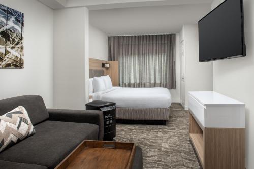 比福德SpringHill Suites by Marriott Atlanta Buford/Mall of Georgia的酒店客房,配有床和沙发