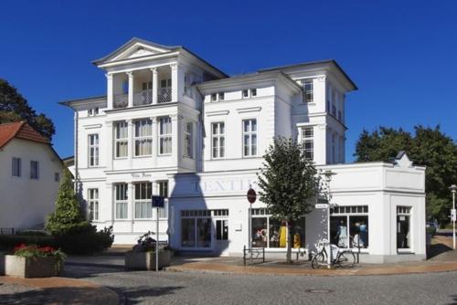 赛巴特班森Villa Anna - Rubin的前面有一间商店的大白色建筑