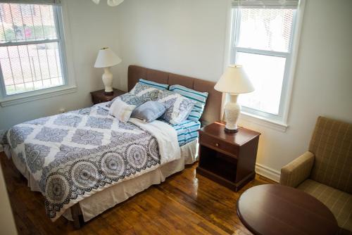 华盛顿Vacation house near downtown DC Free Parking的一间卧室配有一张带两盏灯和一把椅子的床。