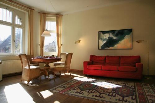 科尔平塞Villa Daheim - FeWo 02的客厅配有红色的沙发和桌子