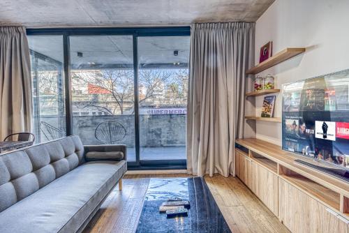 布宜诺斯艾利斯Live Soho Boutique & Apartments Palermo Hollywood的带沙发和大窗户的客厅