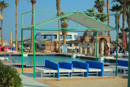 赫尔格达Mashrabiya Hotel的游泳池拥有蓝白长椅和棕榈树