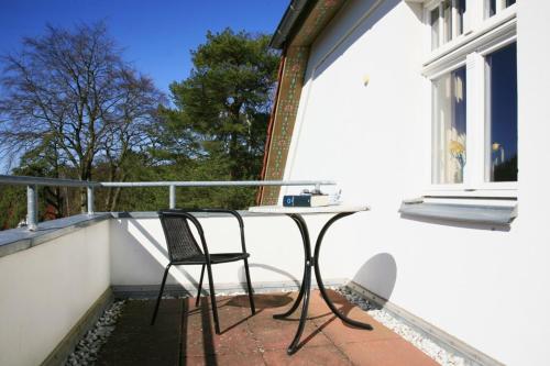 科尔平塞Villa Daheim - FeWo 07的阳台配有桌椅和窗户