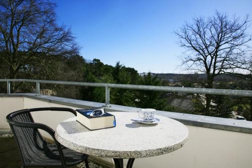 科尔平塞Villa Daheim - FeWo 07的阳台上的桌子和书,杯子