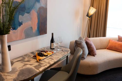 奥克兰Horizon by SkyCity的客厅配有沙发和带酒杯的桌子