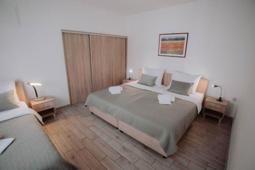 茹帕尼亚Apartments Peric Županja的酒店客房设有两张床和两盏灯。