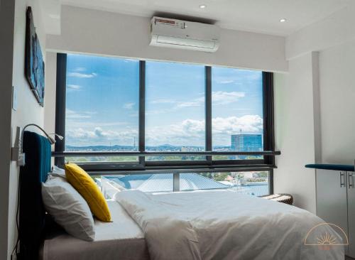 阿克拉SOLEA - Super central, comfortable and modern apartment的一间卧室设有一张床和一个大窗户