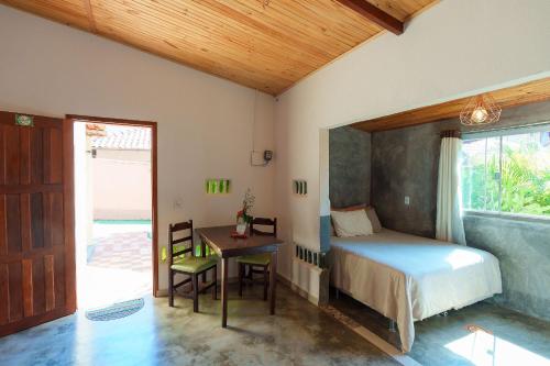戈亚斯州上帕莱索Vita Chalés, na avenida central的一间卧室配有一张床、一张书桌和一个窗户。