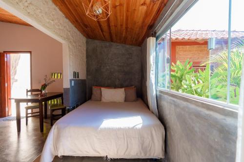 戈亚斯州上帕莱索Vita Chalés, na avenida central的一间卧室设有一张床和一个大窗户