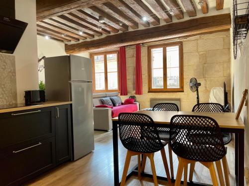 欧苏瓦地区瑟米Appartements chez Delphine et Guillaume au coeur de Semur en Auxois的厨房以及带桌椅的起居室。