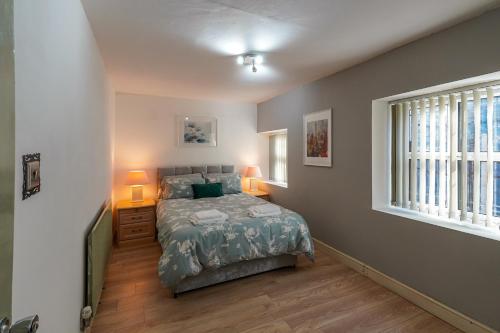 利兹Headingley 2 Bedroom cottage flat Near Universities shops& Park的一间卧室配有一张床、两盏灯和一个窗户。