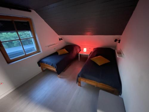 巴拉顿凯奈谢Nóra Apartman的小房间设有两张床和窗户
