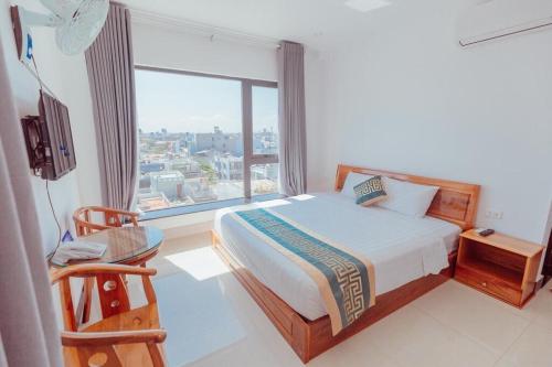 莲三Luxury hotel Phú Yên的一间卧室设有一张床和一个大窗户