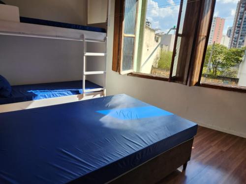 圣保罗Fujima Hostel的客房设有两张双层床和一扇窗户。