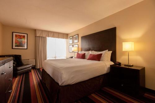 肯纳Clarion Hotel New Orleans - Airport & Conference Center的酒店客房带一张大床和一把椅子