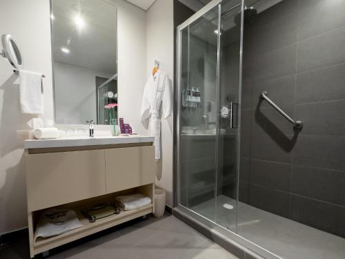 墨西哥城HS HOTSSON Long Stay CDMX Condesa Sur的带淋浴、水槽和玻璃淋浴间的浴室