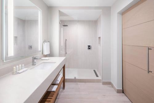 西班牙港西班牙万豪万怡酒店的白色的浴室设有水槽和淋浴。