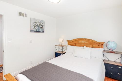 圣巴巴拉Goleta Getaway的白色卧室配有一张带木制床头板的床
