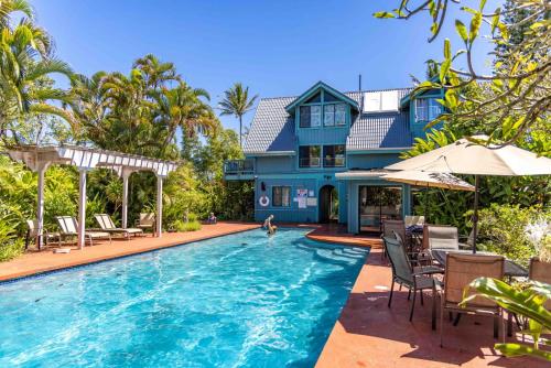 HueloGardenia Room on Tropical Lush Farm in Haiku, Maui的房屋前有游泳池的房子