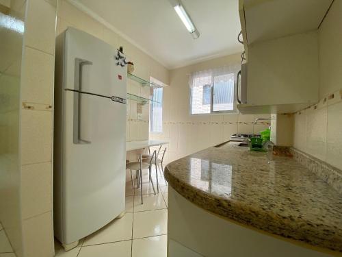 大普拉亚Pé na areia canto do forte II的厨房配有白色冰箱和台面