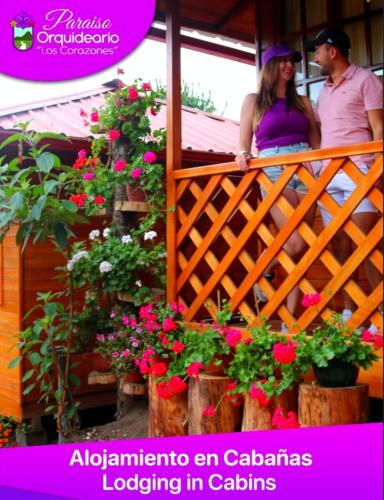 巴尼奥斯Paraiso Orquideario的男人和女人站在鲜花盛开的阳台上