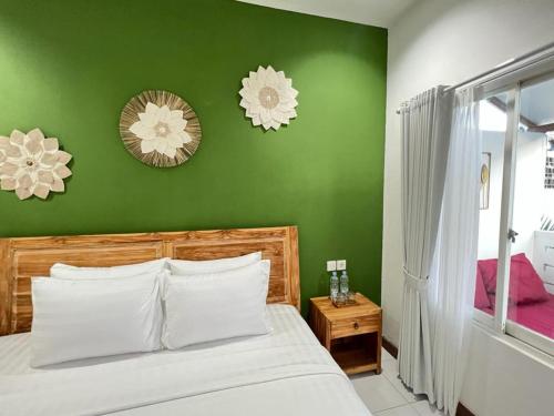坎古Lubdhaka Canggu的绿色卧室,配有床和绿色的墙壁