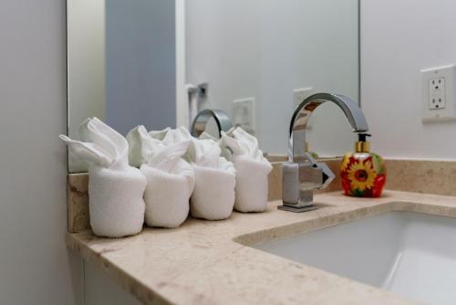列治文山Cozy & Contemporary Suite - Easy Access to Everything的厨房柜台在水槽前配有白色毛巾