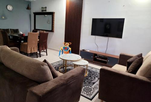 Bandar Baru BangiHomestay FourSeasons @ Bandar Baru Bangi的客厅配有两张沙发和一台电视机