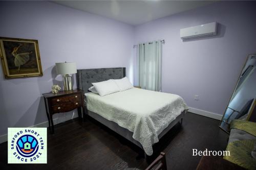 桑福德Boho Nights的一间卧室配有一张床和一张带台灯的桌子