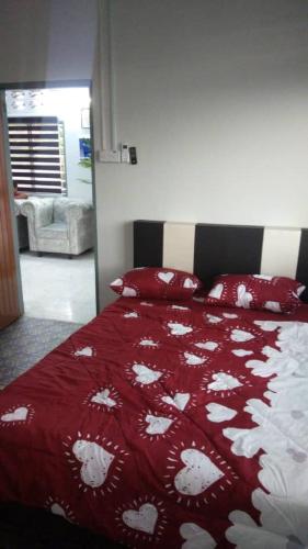 怡保IPOH Homestay的一间卧室配有一张带红白毯子的床